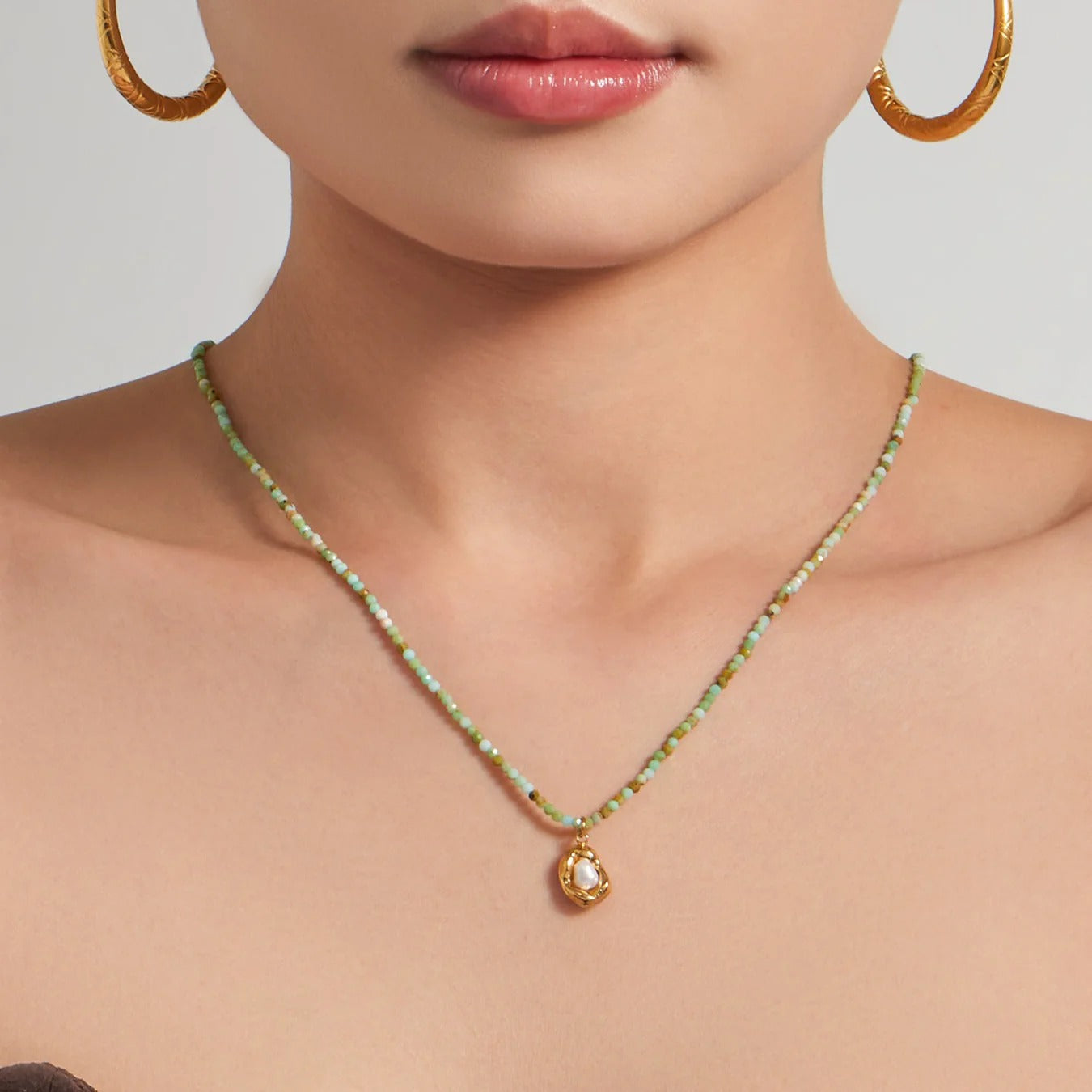 Gold pearl pendant detail on mint green stone bead necklace